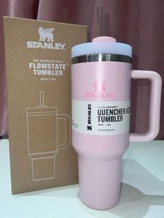 a pink tumbler cup next to a cardboard box