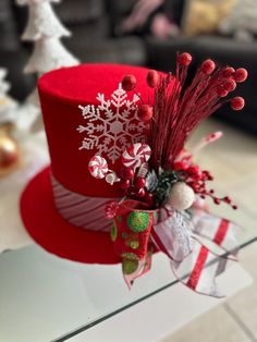 a red top hat with white snowflakes and candy canes on the side