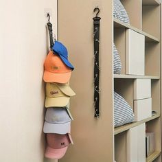 several hats are hanging on the wall next to each other