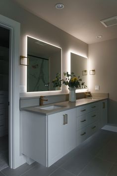 a bathroom with double sinks and large mirrors