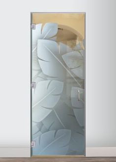 an open glass door with white leaves on it