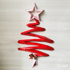 a christmas tree made out of red wooden planks and stars hanging from the ceiling