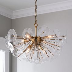 a chandelier hanging from a ceiling in a room with white walls and windows