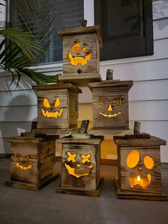 wooden boxes with carved pumpkin faces are sitting on the front porch, lit up by candles