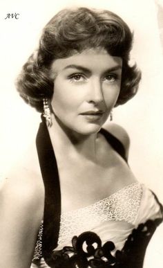 an old black and white photo of a woman in a strapless dress with large earrings