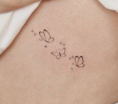 a woman's stomach with two small butterflies on the side and stars in the middle