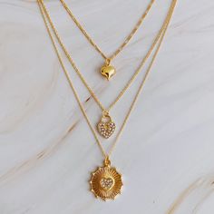 Add a touch of romance and style to your look with our Multi Hearts Multi Layers Necklace. This dainty layered necklace features multiple hearts for a lovely and fashionable touch. Perfect for any outfit, this necklace is a must-have. Dimensions: approximately 14", 16", 18" in layers with a 2" extender Gold plated metal Lead and Nickel compliant Made in China Multi Layer Necklace, Hair Setting, Jewelry Photography, Layered Necklace, Scrunchie Hairstyles, Steel Jewelry, Stainless Steel Jewelry, Headband Hairstyles, Hair Accessories Headbands