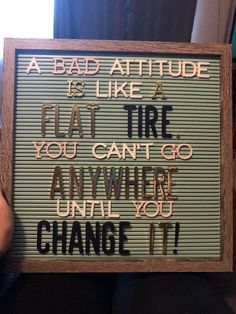 a person holding up a sign that says, a bad attitude is like a flat tire you can't go anywhere until you change it