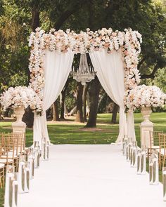 an outdoor wedding setup with white drapes and flowers