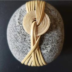 a piece of wood sitting on top of a rock with a knot in it's center