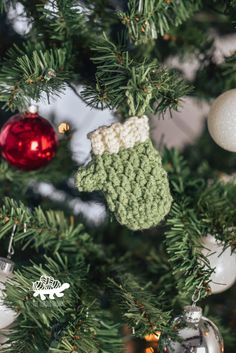 a close up of a christmas tree with ornaments on it and a stocking hanging from the top