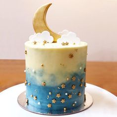 a blue and white cake with gold stars on the top is decorated with a crescent moon