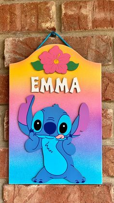 a colorful sign hanging on the side of a brick wall that says,'emma '