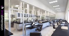 an empty laboratory with lots of desks and chairs in it's center area