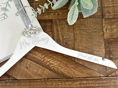 a wedding dress hanger with the word mr and mrs written on it next to a plant