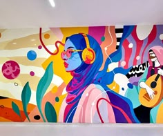 a large colorful painting on the side of a building with headphones hanging from it's ears