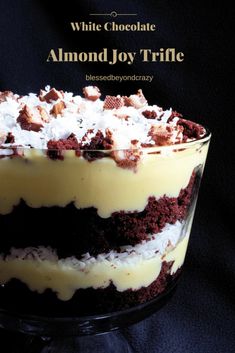 a close up of a cake in a glass dish on a black background with the words white chocolate almond joy trifle