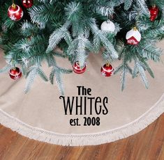 a christmas tree skirt that says the whites est 2009 on it, with ornaments hanging