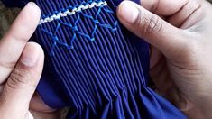 someone is stitching something with blue thread