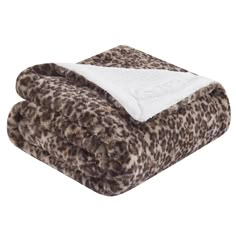 the leopard print blanket is folded up on top of a white and brown thrower