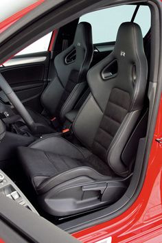 the interior of a red sports car with black leather seats