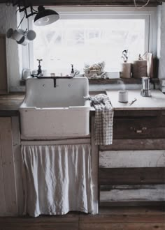 a kitchen sink sitting under a window next to a counter