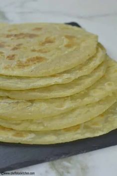 a stack of tortillas sitting on top of a cutting board