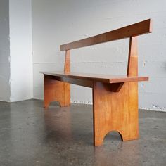 a wooden bench sitting on top of a cement floor