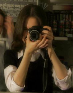 a woman taking a selfie in front of a mirror with a camera attached to her neck