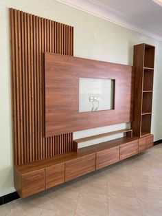 a large wooden entertainment center in a room with tile flooring and wall mounted television