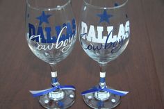 two wine glasses with the word dallas on them are sitting side by side in front of each other