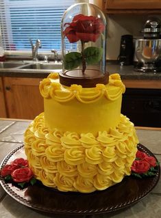 the cake is decorated with yellow icing and red roses