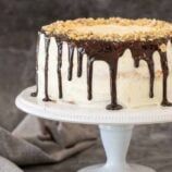 a cake with white frosting and chocolate drizzles