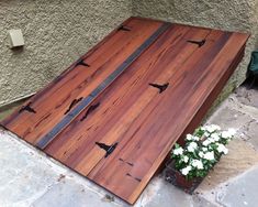 a wooden table sitting on top of a stone floor next to a potted plant