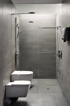 Modern bathroom with grey tiles, walk-in shower, and wall-mounted toilet and bidet. Room Bathroom Design