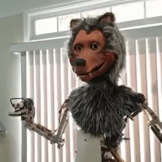 a cartoon character dressed as a wolf holding something in one hand and looking at the camera