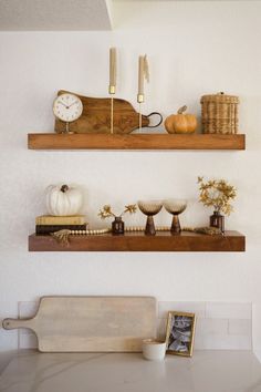 two shelves with candles and other items on them