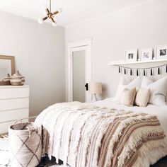 a bedroom with a bed, rugs and pictures on the wall above it's headboard