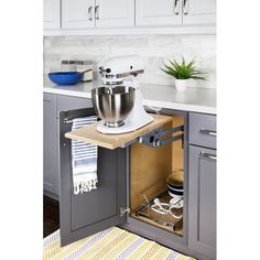 a kitchen scene with focus on the mixer and dishwasher in the open cabinet