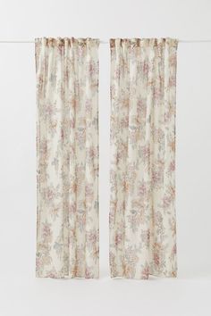 two curtains with floral print on them, one is open and the other has closed