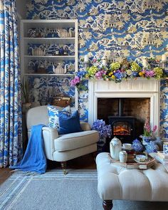 a living room filled with furniture and a fire place in front of a blue wall