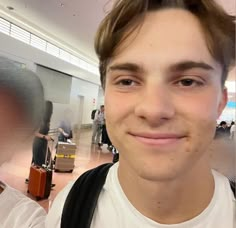 two young men standing next to each other in an airport