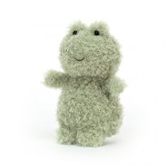 a green stuffed animal sitting on top of a white surface with its arms up in the air