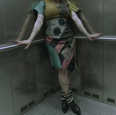 a woman standing in an elevator with her arms outstretched