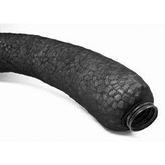 a black pipe is laying on the ground with its end curled up to it's side