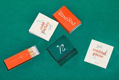 four matches are laying next to each other on a green tablecloth with the words cookbook goose written on them