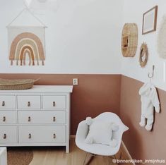 a baby's room with a crib, dresser and pictures on the wall