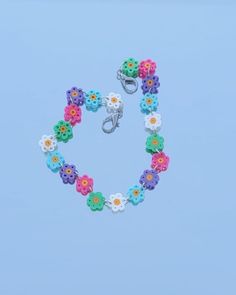 a colorful bracelet with flowers on it and a pair of scissors hanging from the end