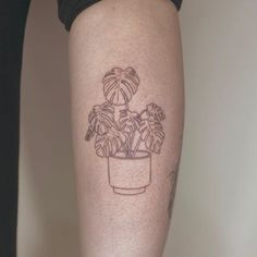 a woman's leg with a tattoo on it that has a potted plant in it