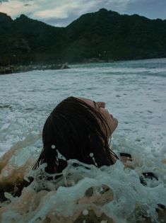 a woman laying in the water with her eyes closed